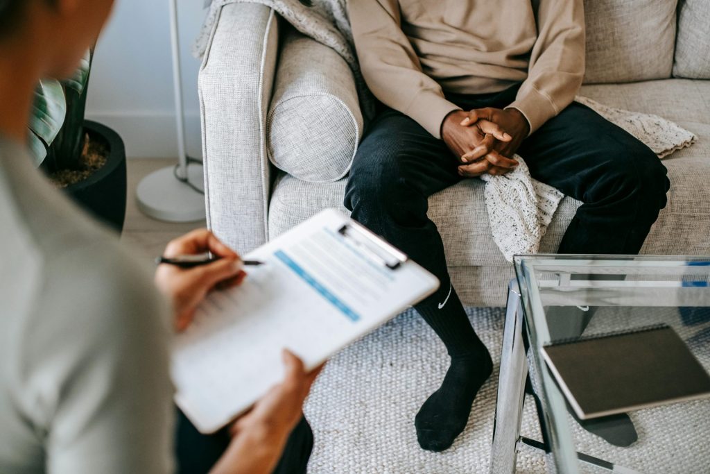 Ein Mann sitzt auf einer Couch beim Psychologen